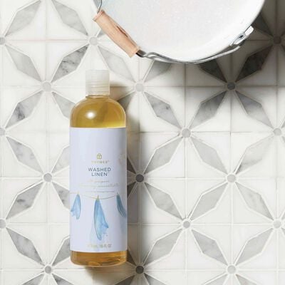 Thymes Washed Linen All-Purpose Cleaning Concentrate for Floors and Surfaces on floor next to bucket